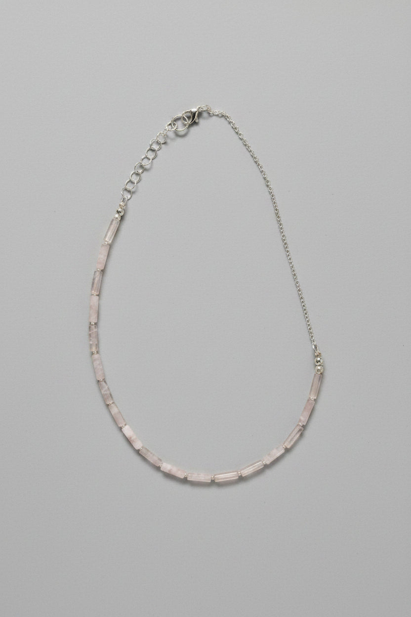 Necklace with pink beads on a gray background